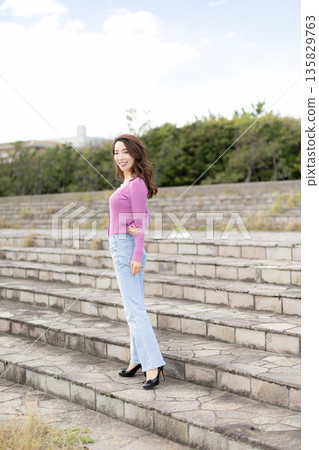 Beautiful woman walking in a city park Beautiful woman walking in a city park 135829763