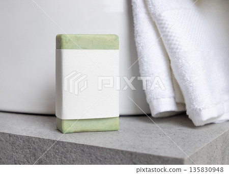 Green soap bar with blank label near white bath towels and basin on grey stone, mockup Green soap bar with blank label near white bath towels and basin on grey stone, mockup 135830948