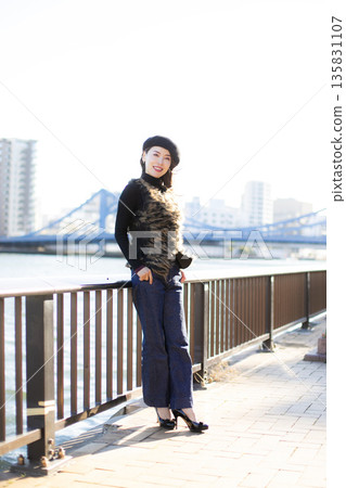 A beautiful woman strolling through a waterfront park 135831107
