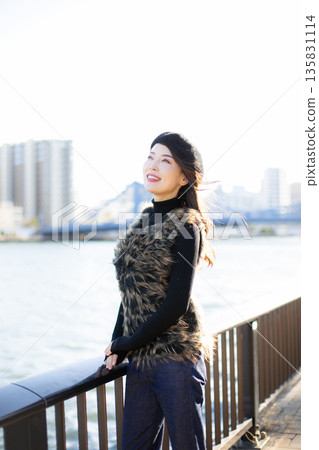A beautiful woman strolling through a waterfront park 135831114