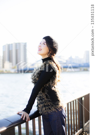 A beautiful woman strolling through a waterfront park 135831118