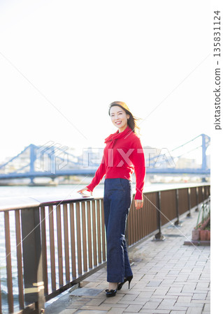 A beautiful woman strolling through a waterfront park 135831124