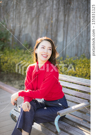Beautiful woman strolling through a city park 135831125
