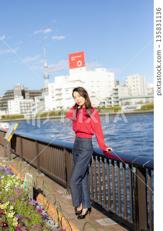 A beautiful woman strolling through a waterfront park 135831136