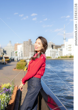 A beautiful woman strolling through a waterfront park 135831138