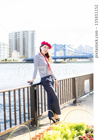 A beautiful woman strolling through a waterfront park 135831152