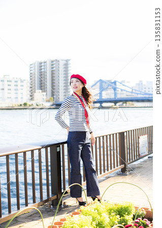 A beautiful woman strolling through a waterfront park 135831153