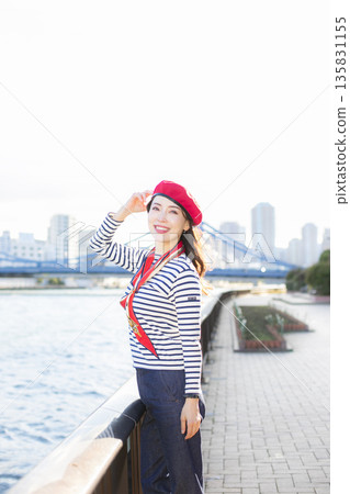 A beautiful woman strolling through a waterfront park 135831155