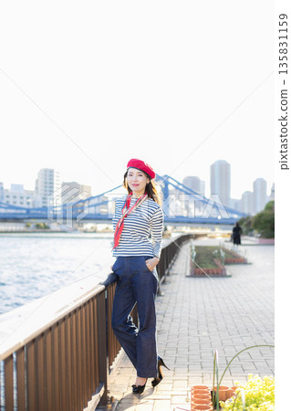 A beautiful woman strolling through a waterfront park 135831159