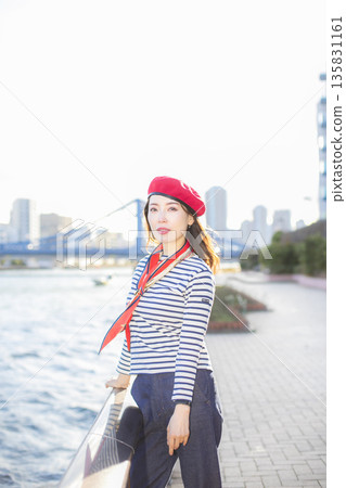 A beautiful woman strolling through a waterfront park 135831161
