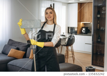 Mop in hands. Female professional cleaning service worker is domestic room 135832242