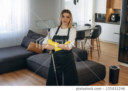 Looking forward. Female professional cleaning service worker is domestic room Looking forward. Female professional cleaning service worker is domestic room 135832246