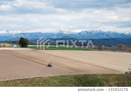 Spring farm work and snowy mountains Spring farm work and snowy mountains 135832278