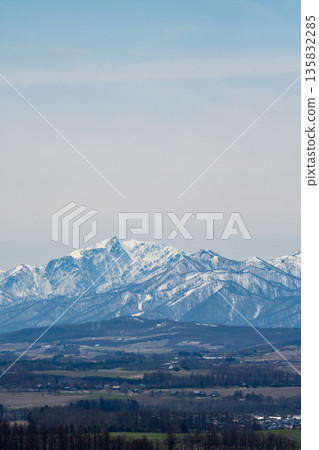 Spring hilly farmland and snow-covered mountaintops Spring hilly farmland and snow-covered mountaintops 135832285