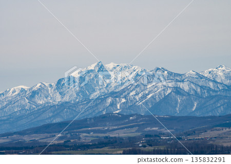 Spring hilly farmland and snow-covered mountaintops Spring hilly farmland and snow-covered mountaintops 135832291