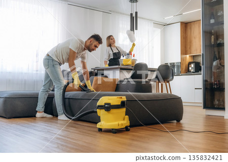 Modern interior of home. Two cleaning service workers are in domestic room 135832421