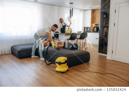 Modern interior of home. Two cleaning service workers are in domestic room 135832424