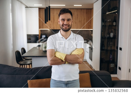 Front view, standing. Male professional cleaning service worker is domestic room Front view, standing. Male professional cleaning service worker is domestic room 135832568