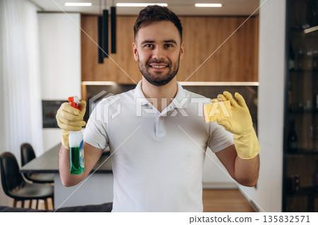 Front view, standing. Male professional cleaning service worker is domestic room 135832571