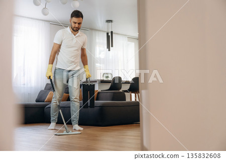 In domestic room. Male professional cleaning service worker In domestic room. Male professional cleaning service worker 135832608