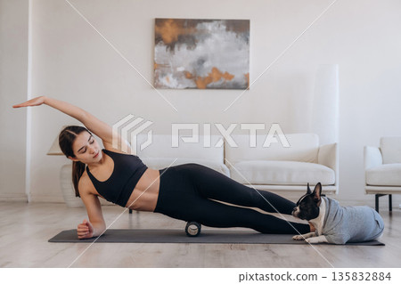 Yoga exercise. Woman with pug dog is at home 135832884
