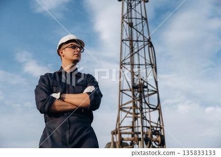 Standing with arms crossed. Construction worker is near boring drilling machine Standing with arms crossed. Construction worker is near boring drilling machine 135833133
