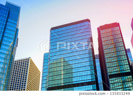 Skyscrapers tower in bright glass exteriors sunlight on sunset. Tower facade office buildings 135833249