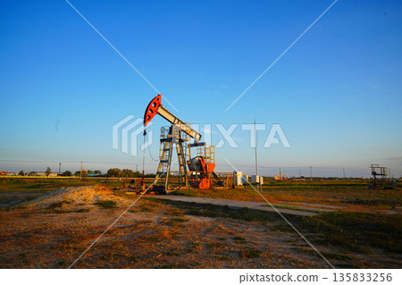 Pumpjack in oil well of oil field on sunrise in Industrial crude area. Crude pump jack on oil field 135833256