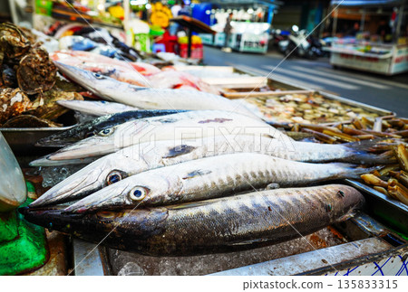 Fresh fish sale at local market in early morning. Freh seafood in ice on counter in a grocery store 135833315