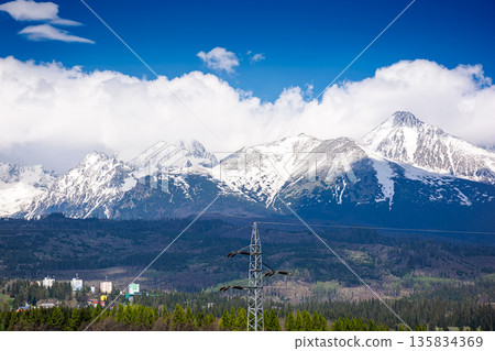 snow capped mountain peaks of high tatras in spring. scenic view of popular travel destination for remote trekking in slovakia, europe. alpine landscape with blue sky and clouds above the ridge snow capped mountain peaks of high tatras in spring. scenic view of popular travel destination for remote trekking in slovakia, europe. alpine landscape with blue sky and clouds above the ridge 135834369