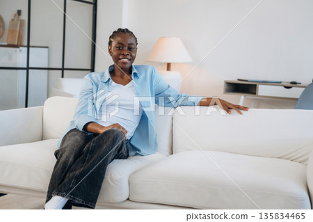 Looking forward, sitting and smiling. Woman is at home in domestic room 135834465