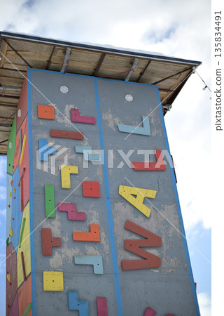 Colorful climbing wall against blue sky 135834491