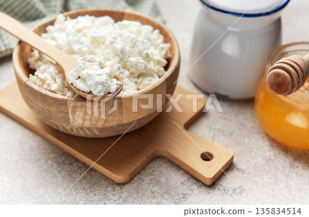 Cottage cheese in wooden bowl with honey dipper Cottage cheese in wooden bowl with honey dipper 135834514