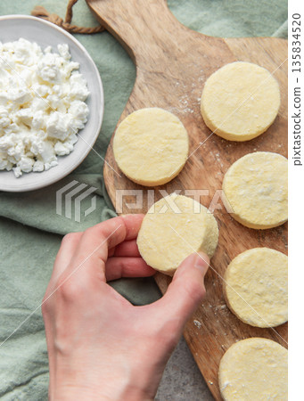 Preparing syrniki cottage cheese pancakes on cutting board Preparing syrniki cottage cheese pancakes on cutting board 135834520