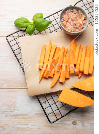 Preparing raw sweet potato fries for healthy cooking Preparing raw sweet potato fries for healthy cooking 135834526