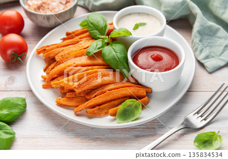 Sweet potato fries with ketchup and dipping sauce 135834534