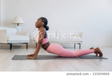 Spine exercise. Woman is doing yoga at home Spine exercise. Woman is doing yoga at home 135834609