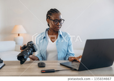 Sitting by the laptop. Woman is at home in domestic room Sitting by the laptop. Woman is at home in domestic room 135834667