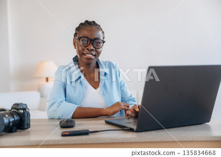Sitting by the laptop. Woman is at home in domestic room 135834668