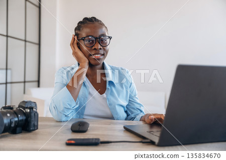 Sitting by the laptop. Woman is at home in domestic room Sitting by the laptop. Woman is at home in domestic room 135834670
