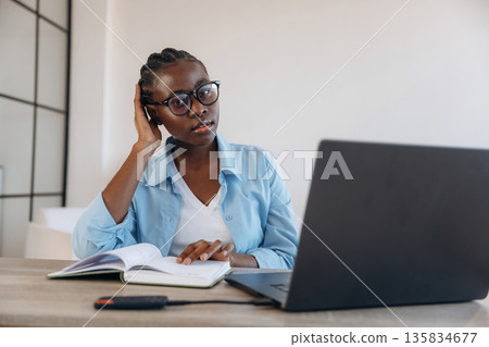 Information in the notepad, sitting. Woman is at home in domestic room Information in the notepad, sitting. Woman is at home in domestic room 135834677