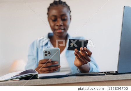 Credit card, online payment. Woman is at home in domestic room 135834700