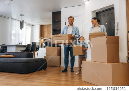 Bunch of boxes. Family of husband, wife and son are moving into new house 135834951