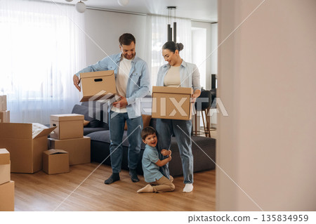 Bunch of boxes. Family of husband, wife and son are moving into new house 135834959