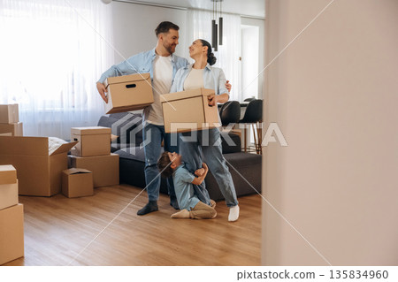 Bunch of boxes. Family of husband, wife and son are moving into new house Bunch of boxes. Family of husband, wife and son are moving into new house 135834960