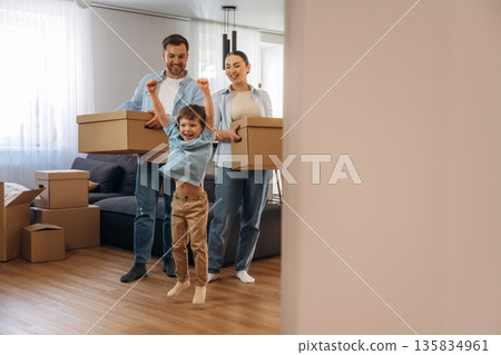 Bunch of boxes. Family of husband, wife and son are moving into new house Bunch of boxes. Family of husband, wife and son are moving into new house 135834961