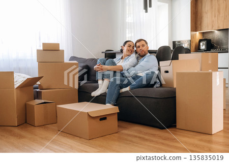 Black sofa, sitting and relaxing. Happy couple moved into new house 135835019