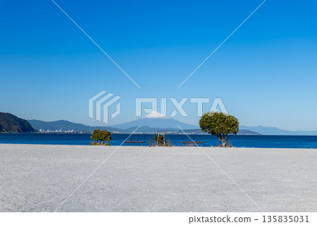 A white sandy beach with benches overlooking Mt. Fuji and the ocean 135835031
