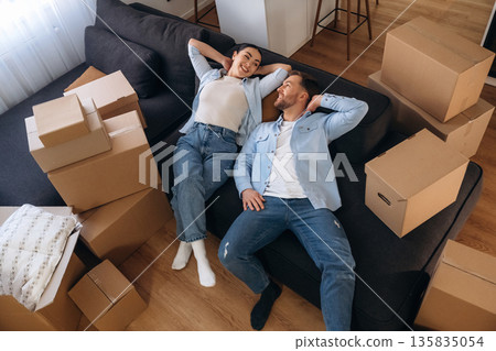 Wellness, lying down on sofa. Happy couple moved into new house Wellness, lying down on sofa. Happy couple moved into new house 135835054