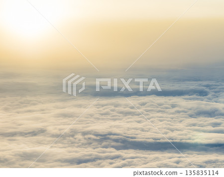 Aerial view of a sea of clouds shining in the setting sun 135835114